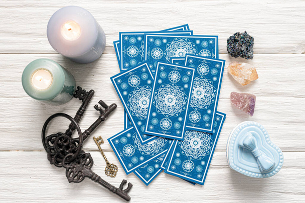 Blue tarot cards and key to the fate on white wooden table background. Clue to the fate concept. - Fotoğraf, Görsel