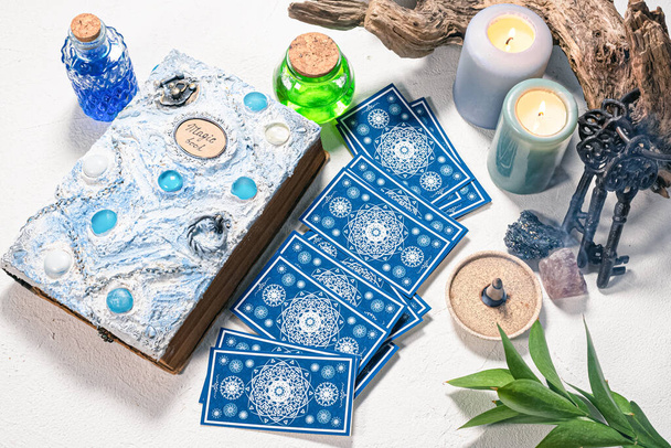 Tarot cards and white magic book on the white table background. - Zdjęcie, obraz