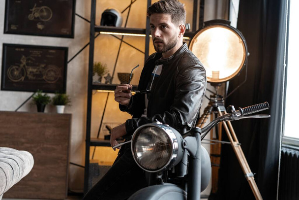 Stylish young man in leather jacket sitting on motorbike. - Фото, изображение