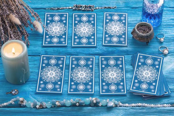 Blue tarot cards deck on blue wooden table background. - 写真・画像