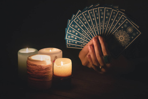 Wahrsagerin liest Zukunft mit Tarotkarten im Licht des Kerzenkonzepts. - Foto, Bild
