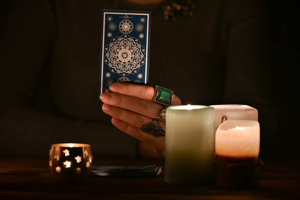 Fortune teller shows a tarot card close up. - Foto, Imagem
