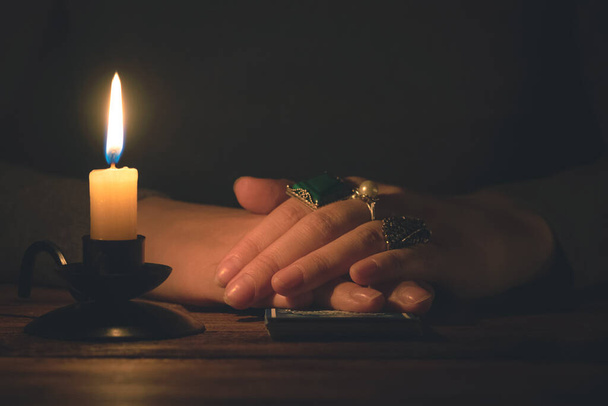 Fortune teller reading a future by tarot cards in the light of candle concept. - Valokuva, kuva