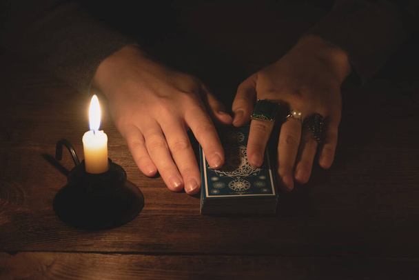 Fortune teller reading a future by tarot cards in the light of candle concept. - Foto, afbeelding