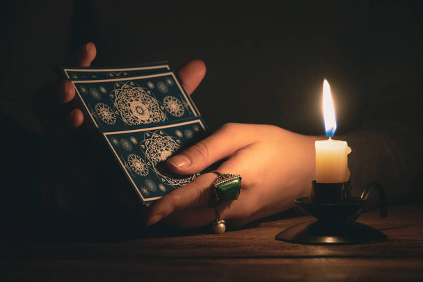 Fortune teller reading a future by tarot cards in the light of candle concept. - Foto, immagini