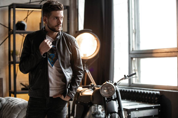 Perfect man. Young hipster in leather jacket standing in room. - Fotografie, Obrázek
