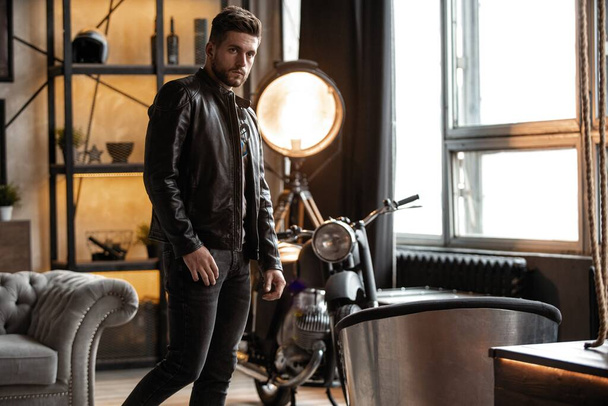 Perfect man. Young hipster in leather jacket standing in room. - Foto, Bild