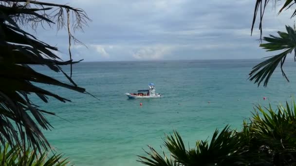 Boat at sea in front of the ancient Mayan fortress in Tulum Yucatan, Mexico - Filmagem, Vídeo