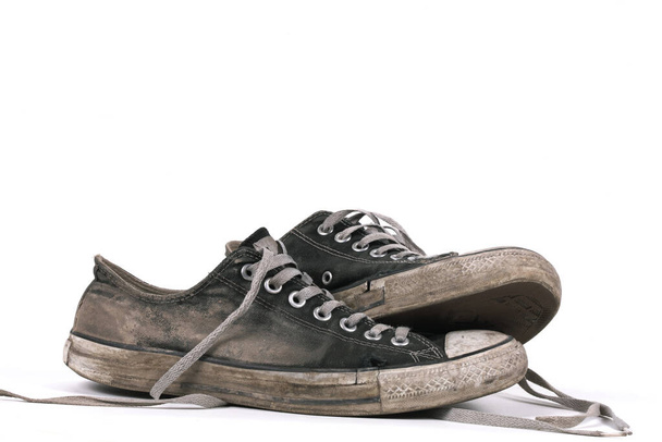 Oud en vuil zwart canvas sneakers, geïsoleerd - Foto, afbeelding