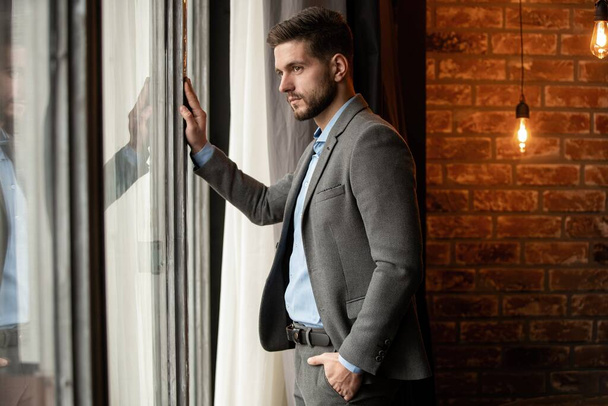 Thinking businessman in the office looking through the window. - Foto, Imagem