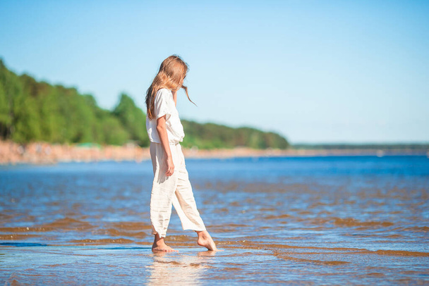 Rozkošná holčička na pláži během letních prázdnin - Fotografie, Obrázek