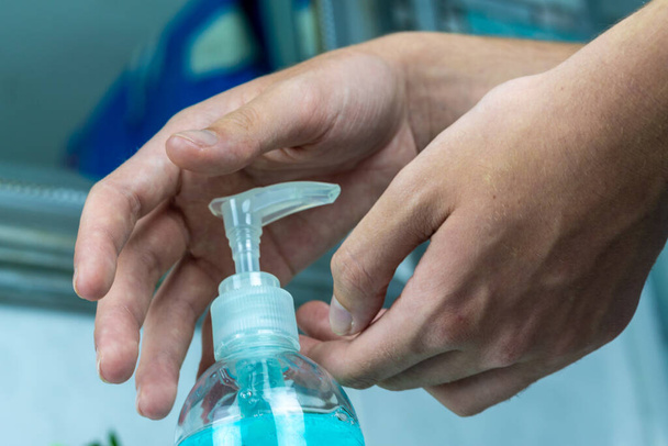 Kuinka käyttää hydroalkoholipitoista geeliä käsien puhdistamiseen. käsien desinfioinnin käsite. Covid-19 käsienpuhdistusaine - Valokuva, kuva