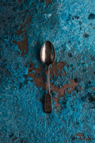 old metal spoon on a blue background - 写真・画像