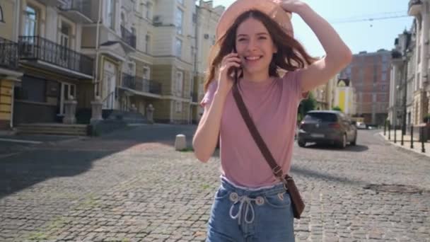 Piękna młoda kobieta turysta w centrum miasta rozmawia przez telefon - Materiał filmowy, wideo