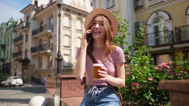 Beautiful Young Woman tourist with takeout coffee in the City Center talking on the phone - Video, Çekim