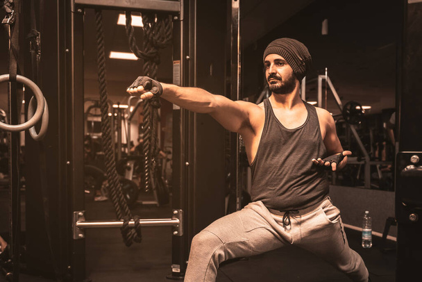 Un homme sportif dans la salle de gym fait des exercices de yoga. Virabhadrasana : la position du Guerrier. Yoga avantages mentaux. - Photo, image