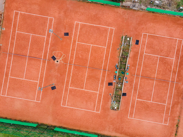 Drone vista aérea tiro de cima para baixo na quadra de tênis três playground com argila no dia vazio sem pessoas
 - Foto, Imagem