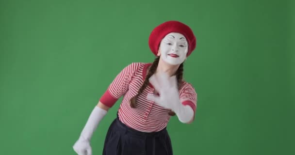 Mime-Frau winkt vor grünem Hintergrund - Filmmaterial, Video