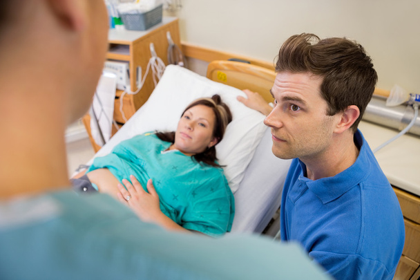 Man And Pregnant Woman Listening To Nurse In Hospital - Zdjęcie, obraz