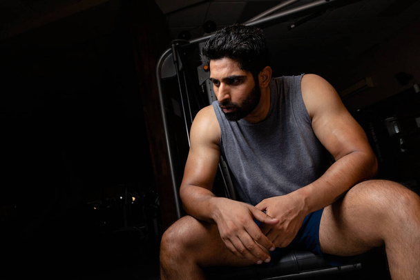 Athlete sitting on table after heavy workout and full on sweating Low angle shot - Photo, Image