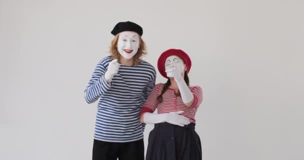 Mimikkünstlerpaar lacht über weißen Hintergrund - Filmmaterial, Video
