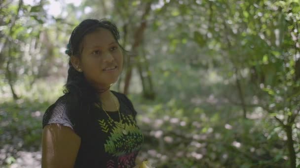 Pando / Bolivia - March 29 2018: Young and Indigenous Woman Laughing and Holding a Fruit in the Bolivian Amazon - Materiał filmowy, wideo