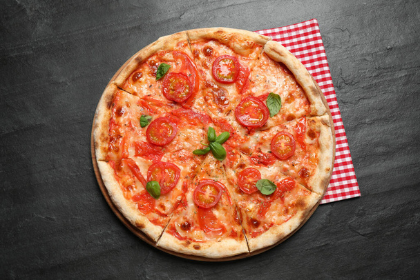 Lezzetli pizza Margherita, koyu gri masa, üst manzara. - Fotoğraf, Görsel
