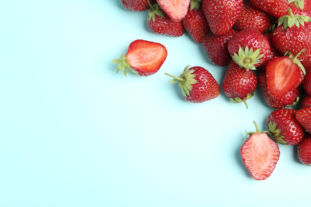 Tasty ripe strawberries on light blue background, flat lay. Space for text - Fotó, kép