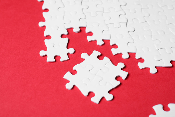 Blank white puzzle pieces on red background - Photo, Image