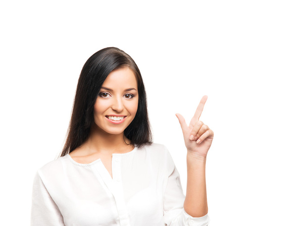 A young businesswoman pointing at something on white - Foto, Bild