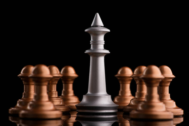 チェスキングは黒を背景にポーンと立つ。不公平な対立 - 写真・画像