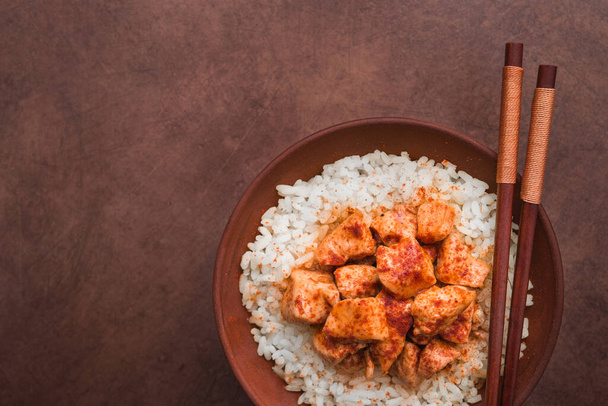 Індіанська курка з білим рисом на коричневому тлі. гарячий обід. угорі - Фото, зображення