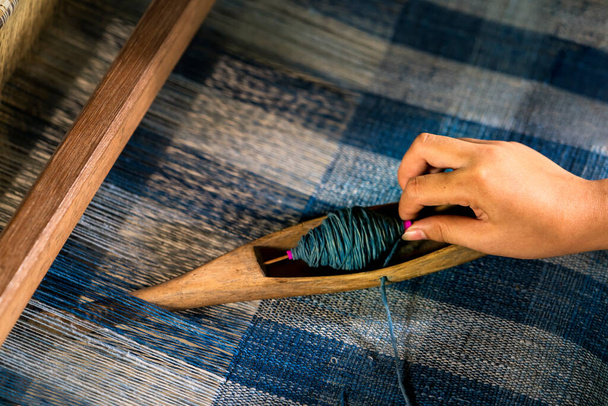 Crafts and craftsmanship. Traditional Isan Thai Cotton indigo weaving. Woman hand weaving Cotton Indigo in traditional way at manual loom. Thailand . Selective focus. - Photo, Image