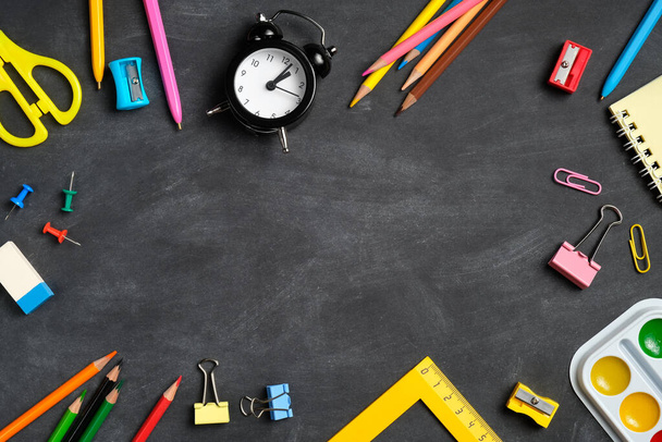 Frame of school supplies on black board background. Flat lay, top view, overhead. Back to school concept. - Valokuva, kuva