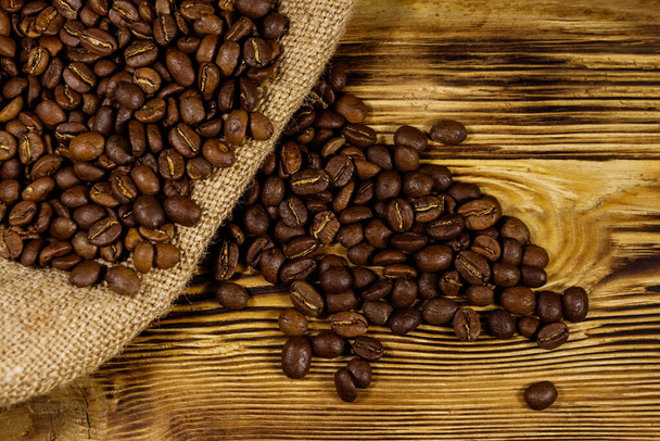 grãos de café torrados em pano de saco na mesa de madeira - Foto, Imagem