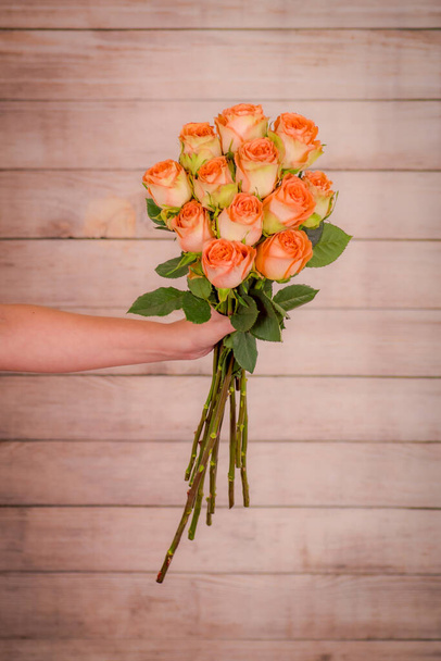 Women hand holding a bouquet of Country Home roses variety, studio shot. - Foto, imagen