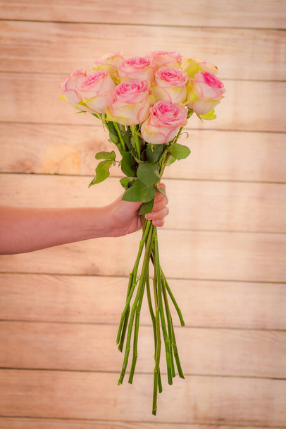 Women hand holding a bouquet of Esperance roses variety, studio shot. - Foto, imagen