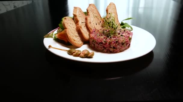 Raw tartar meat with spices, croutons and herbs. Beef tartar with capers. Beef tartar with slices of bread.  Raw meat tartare for gourmet meat. - Footage, Video