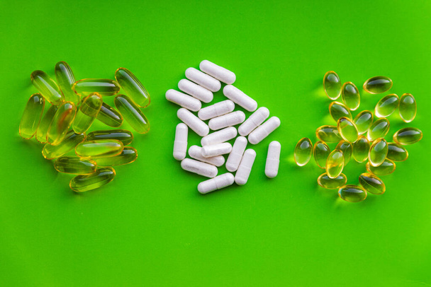 Групи білих вітамінних добавок зі стопкою жовтих таблеток желе
 - Фото, зображення