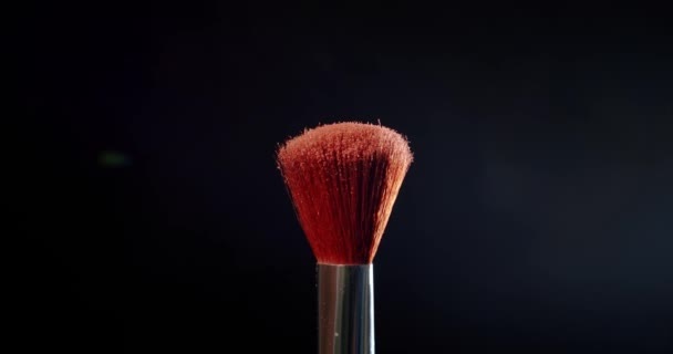 Two Make-up brush with powder on black background Colour Paint Concept Slow Motion. - Felvétel, videó