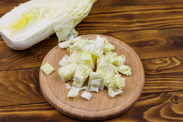Chopped chinese cabbage on cutting board on wooden table - Фото, зображення