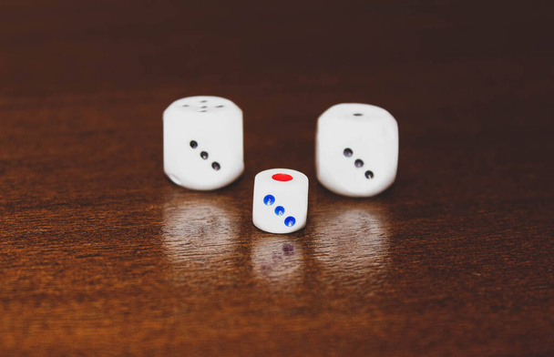 Trois dés pour les jeux de société sur une table en bois. Concentration sélective. - Photo, image