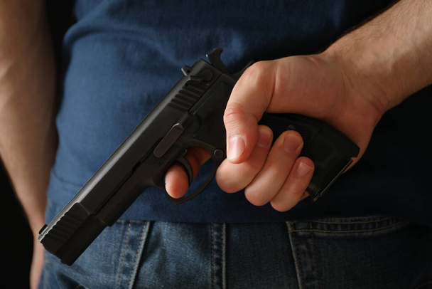 Muž drží zezadu zbraň. Sebeobranná zbraň - Fotografie, Obrázek