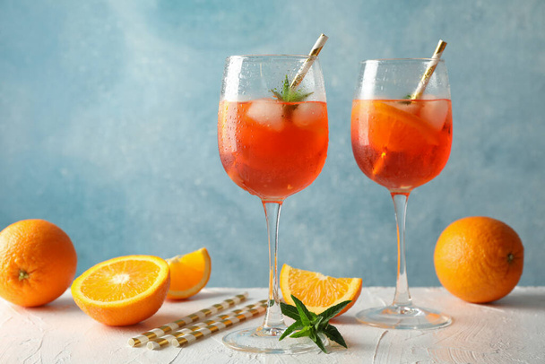 Composition with aperol spritz cocktail against blue background - Photo, image