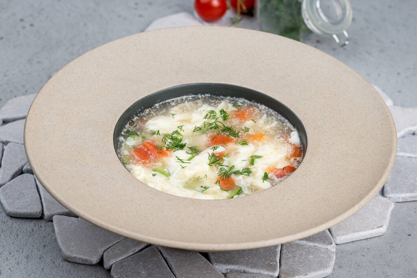 Soup with egg and fresh herbs in a deep plate - Zdjęcie, obraz