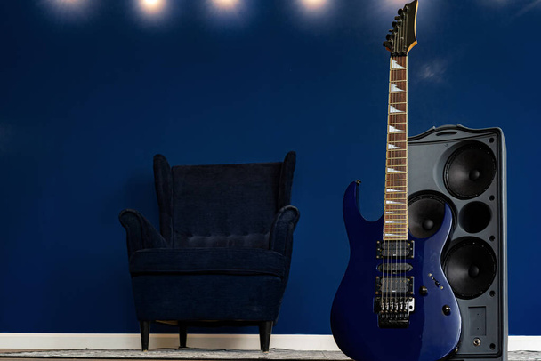 Guitar setup against classic blue wall in apartment - Фото, зображення