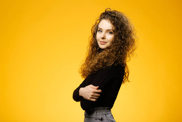 Pretty girl with curly hair isolated on yellow background - Foto, Bild