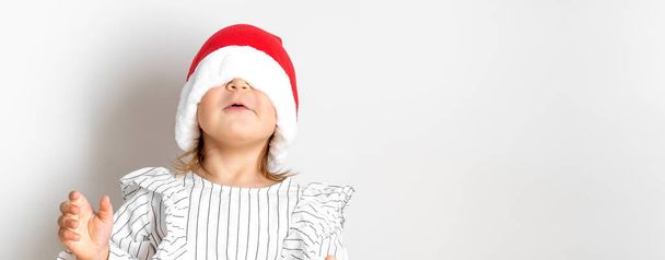 Portrait of toddler girl in red hat on Christmas. Surprise concept - Foto, Imagen