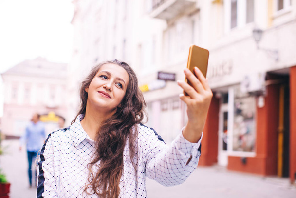 Woman making a cute selfie while walking - Valokuva, kuva
