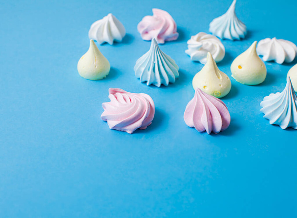 Delicious aerial meringue cookies on blue surface - Photo, image